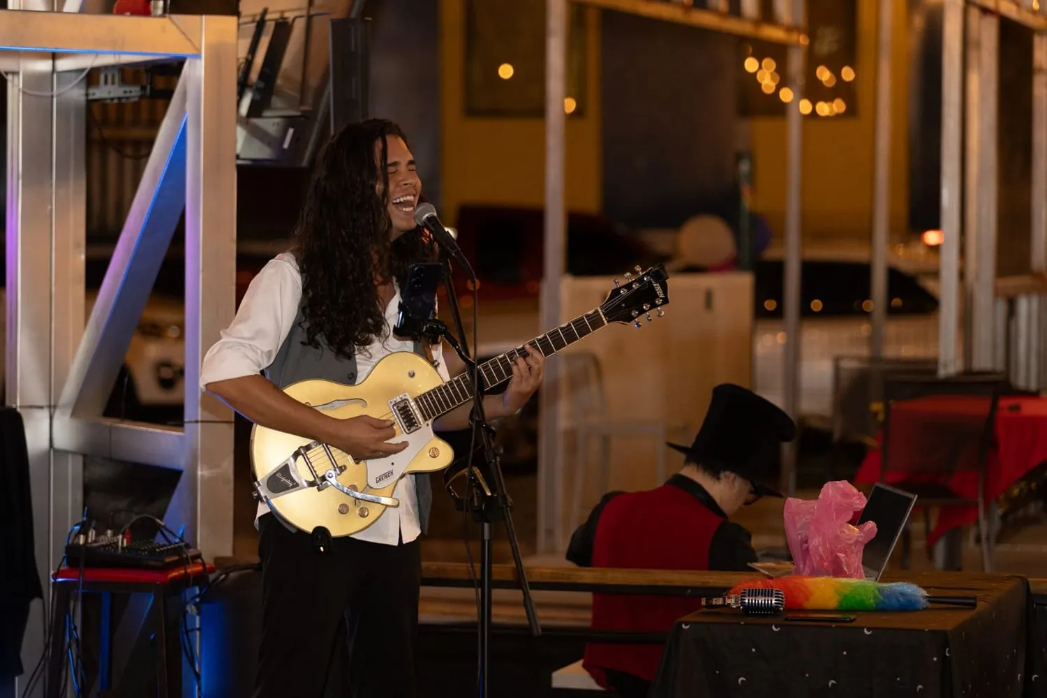 Un cantante con guitarra eléctrica tocando en vivo de noche en la plaza